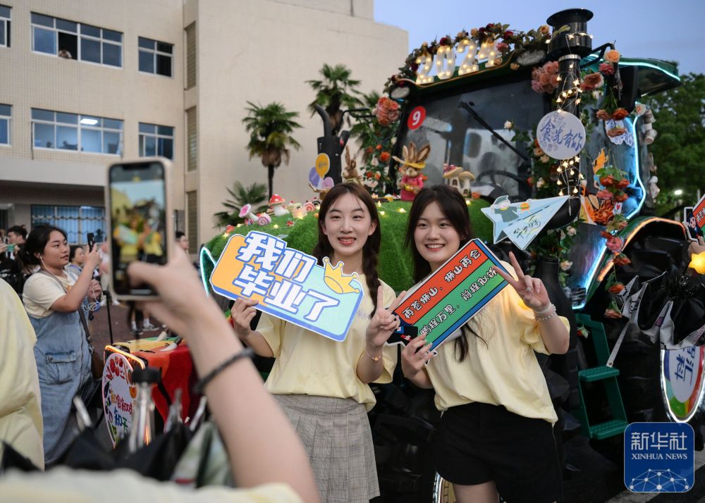 6月21日,3044澳门永利集团欢迎您学生在农机花车前拍照留念。